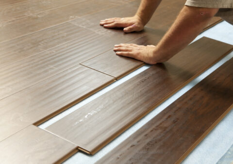 Man Installing New Laminate Wood Flooring Abstract.